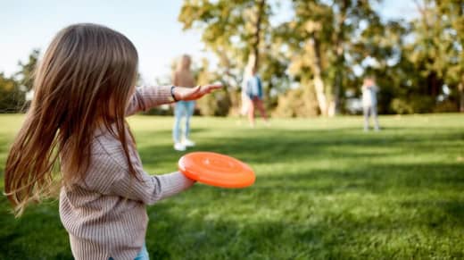 A kid playing Frisbees on a picnic