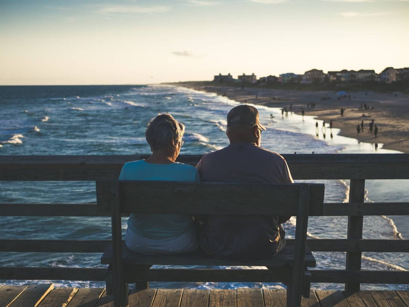 A senior couple relaxing on a bench near beach