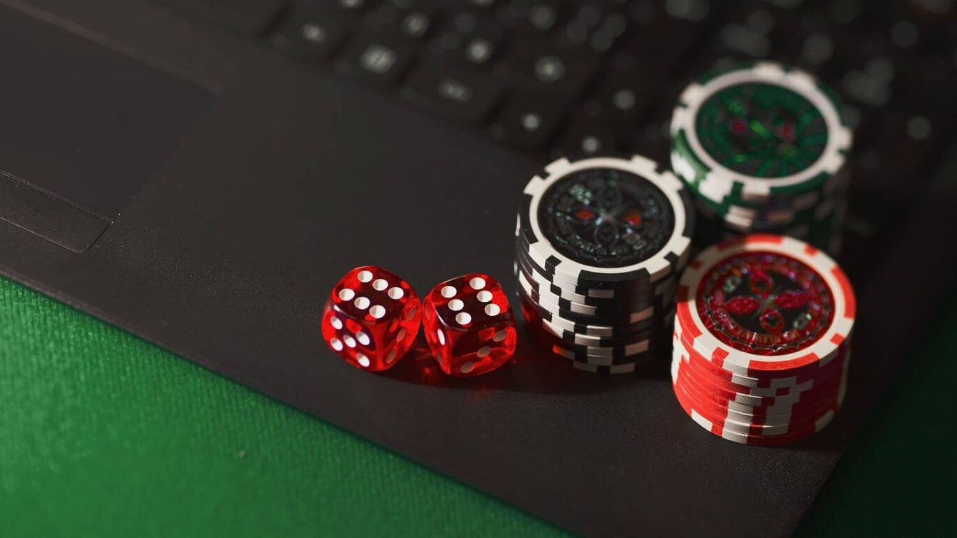 Casino chips and Dice are placed on a Laptop's keyboard
